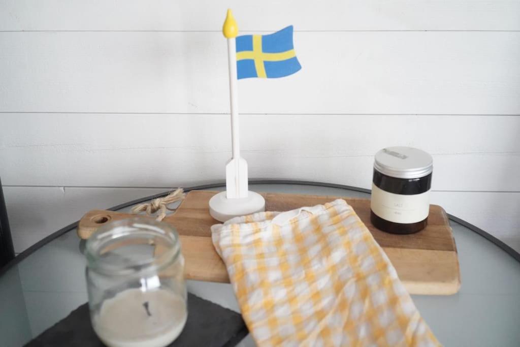 a glass table with a candle and a flag on it at Nybyggt -med spabad, bastu och nära stor badstrand in Kungsör