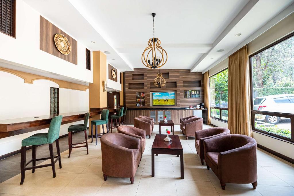 uma sala de espera num hotel com cadeiras e mesas em Heri Heights Hotel Apartments, SureStay Collection by Best Western em Nairobi
