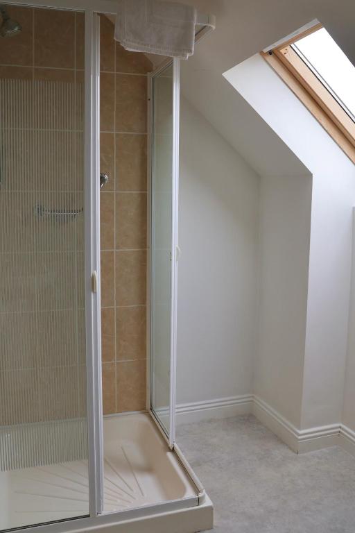 a shower with a glass door in a bathroom at Doolin Village Lodges in Doolin