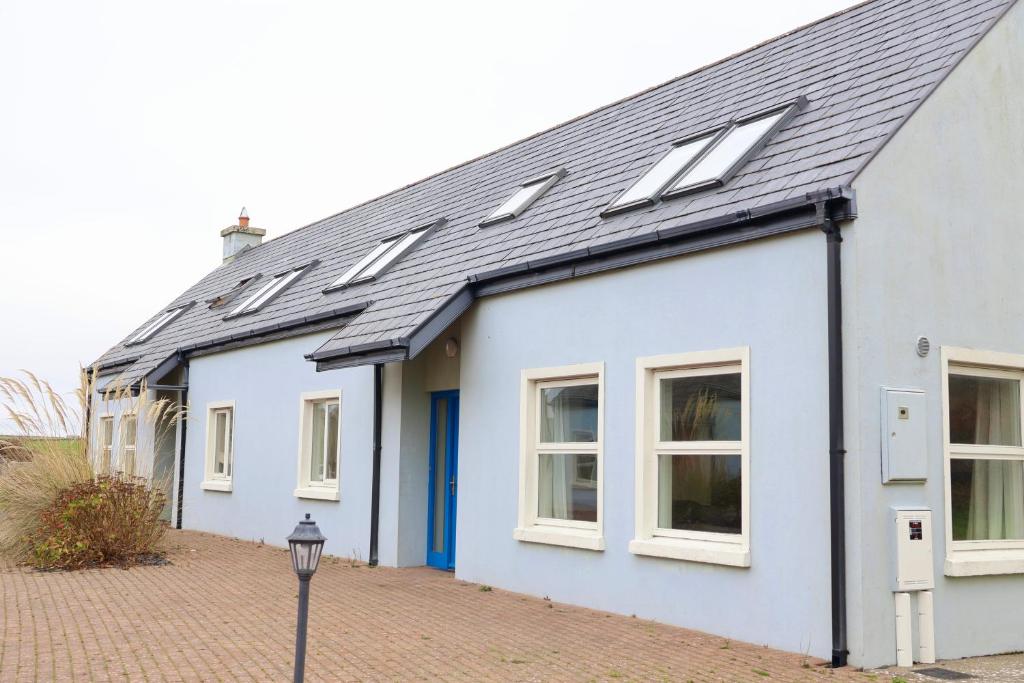 a white house with solar panels on the roof at Doolin Village Lodges in Doolin