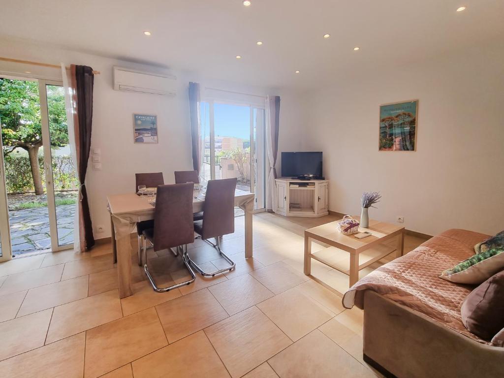 un salon avec une table et un canapé dans l'établissement Le Jardin d'Été à la Mer - T2 avec jardin, clim, parking, à Cavalaire-sur-Mer
