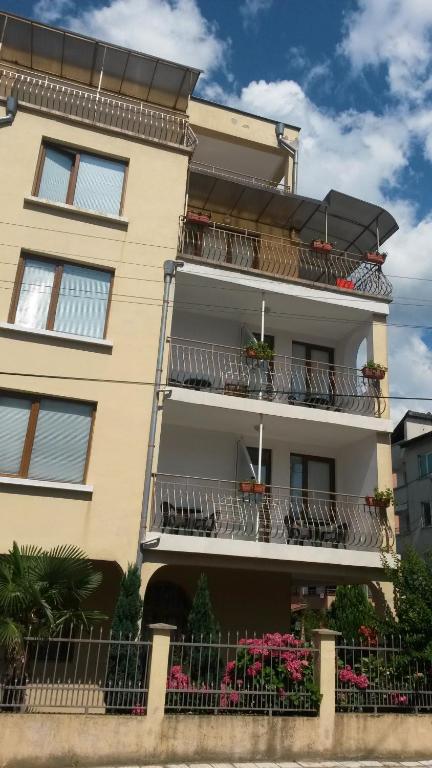 an apartment building with balconies and flowers on it at Къща за гости Кадиеви in Primorsko
