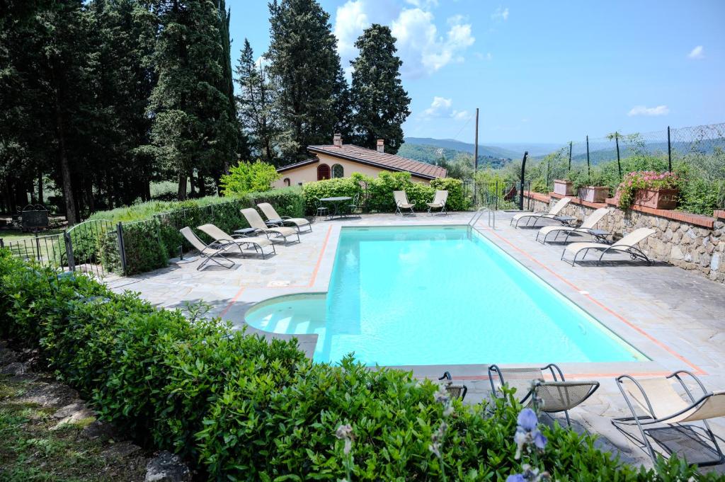 a swimming pool with lounge chairs and a house at Villa Casa del Mugnaio in Pontassieve