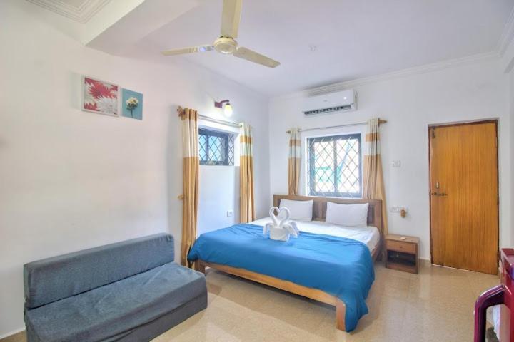 巴加Rosy Guest House since 1989的一间卧室配有蓝色的床和沙发