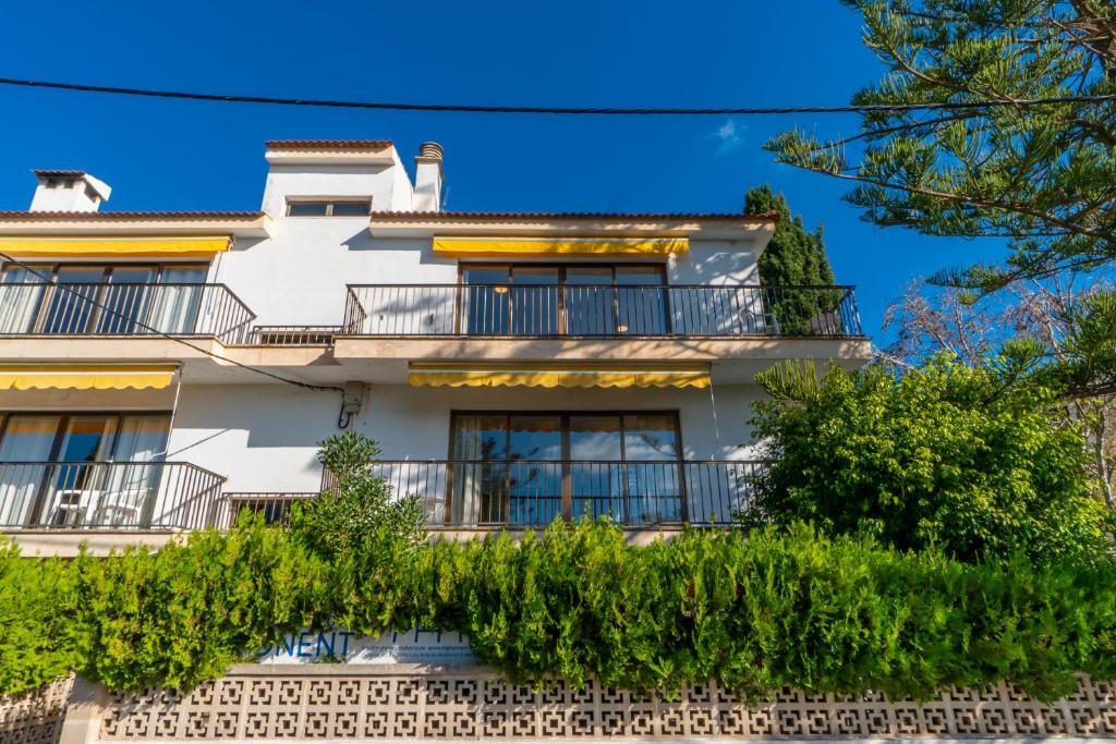un bâtiment blanc avec des balcons et des arbres dans l'établissement Ponent Cala Ratjada Apartments D, à Cala Ratjada