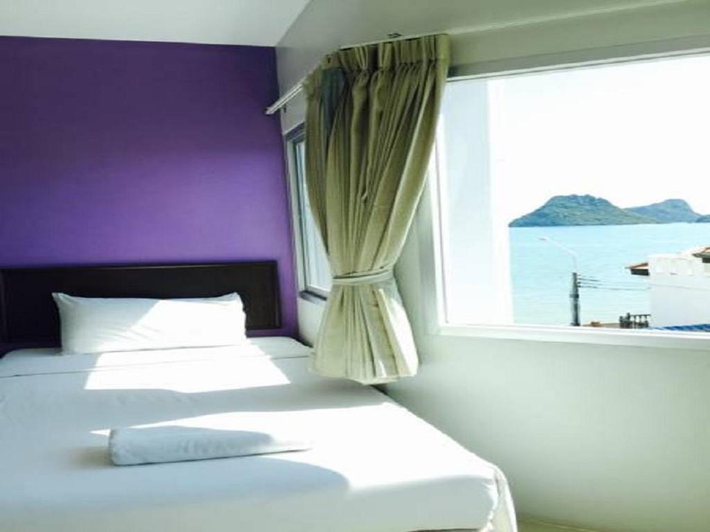 a bedroom with two beds and a window at Prachuap Beach Hotel in Prachuap Khiri Khan