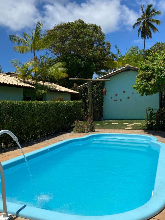 a swimming pool in front of a house at Casa Jasmim Imbassaí-BA in Mata de Sao Joao