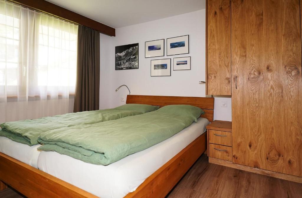 a bedroom with a bed and a wooden cabinet at Chalet Valeria in Saas-Fee