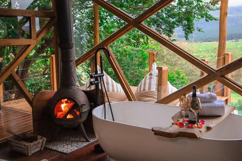 a bathroom with a bath tub and a fireplace at Quaint Luxury Villas in Graskop