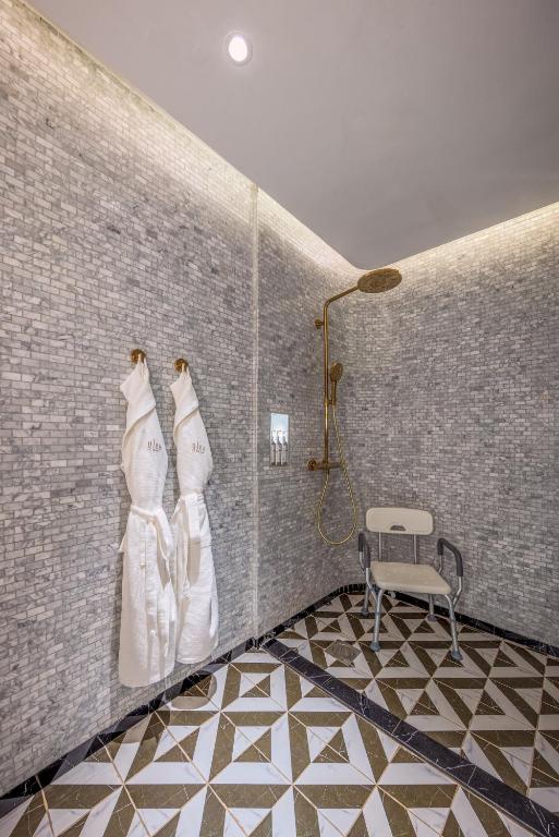 a bathroom with white robes hanging on a wall at Glee Nairobi, a Preferred LVX Hotel in Nairobi