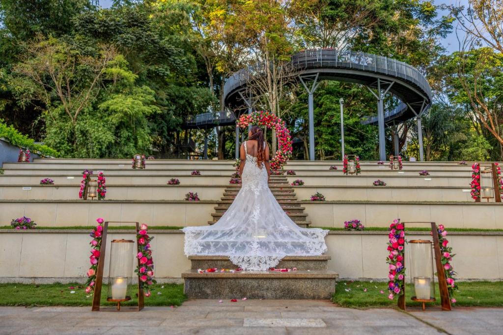 a bride in a white dress sitting on some stairs at Glee Nairobi, a Preferred LVX Hotel in Nairobi