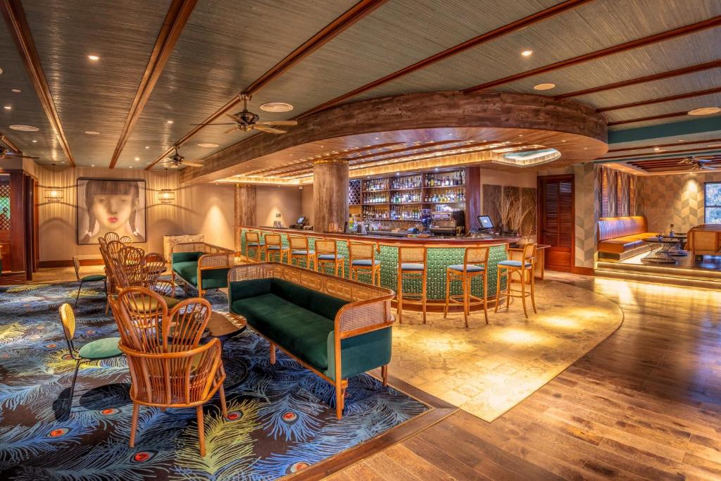 a room with a bar with chairs and a table at Glee Nairobi, a Preferred LVX Hotel in Nairobi