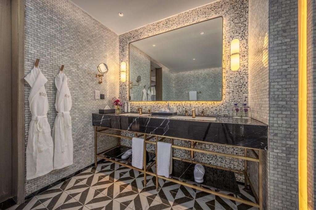 a bathroom with two sinks and a large mirror at Glee Nairobi, a Preferred LVX Hotel in Nairobi