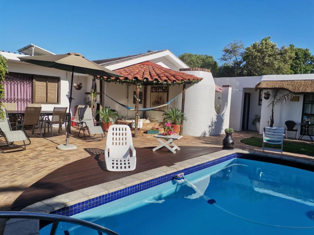ein Haus mit Swimmingpool und Terrasse in der Unterkunft Pelican Place Guest Cottages in Durbanville