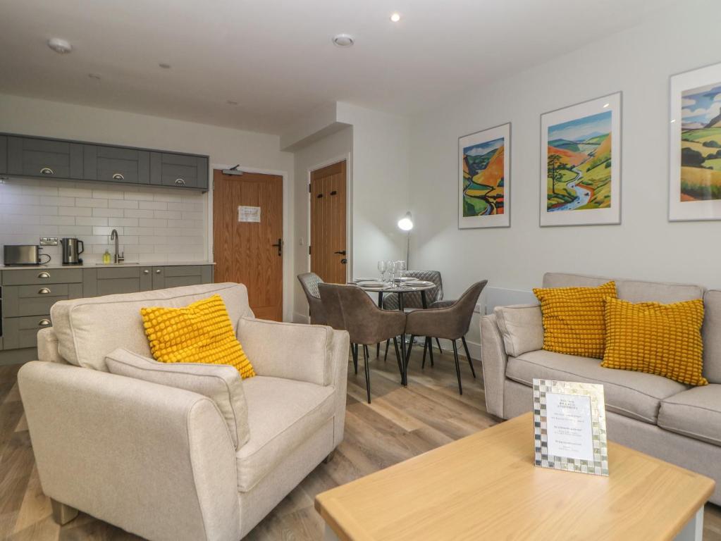 a living room with two couches and a table at 2 Rock Mill Holiday Apartments in Eyam