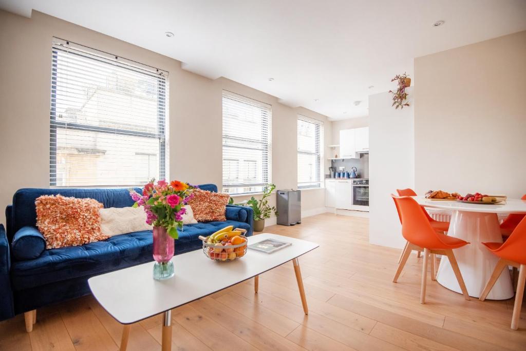 a living room with a blue couch and a table at Dream Stays Bath - John Street Apartments in Bath