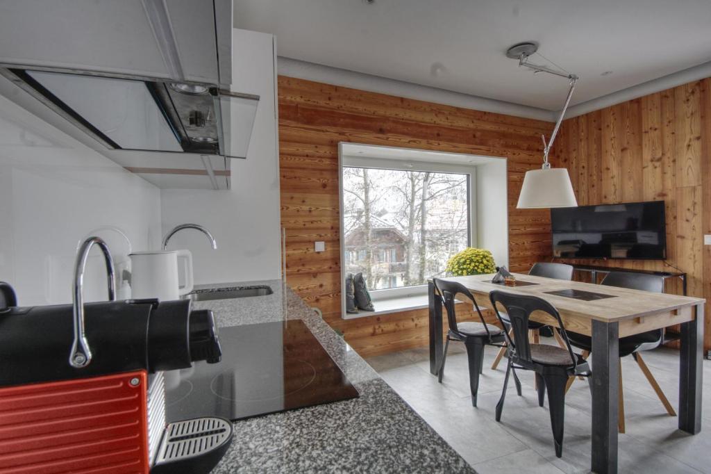 une cuisine et une salle à manger avec une table et des chaises dans l'établissement Apartment Bonatti 202, à Chamonix-Mont-Blanc