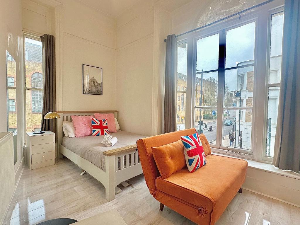 Un dormitorio con una cama y una silla y una ventana. en Guesthouse 81, en Londres