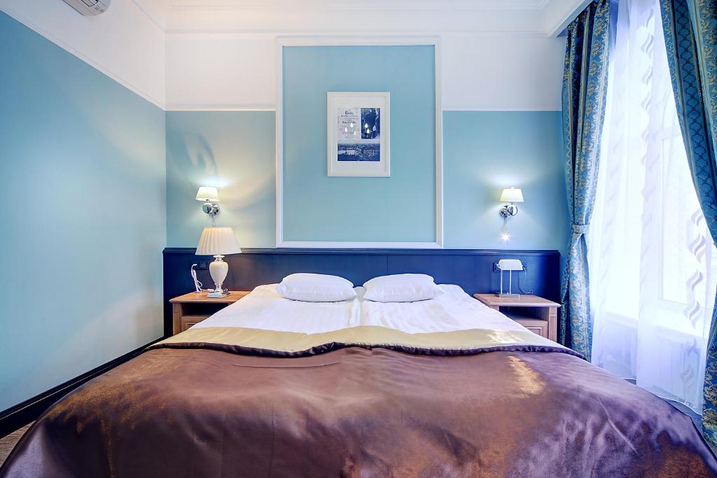 ein Schlafzimmer mit einem großen Bett mit blauen Wänden in der Unterkunft Petersburg's Elegy in Sankt Petersburg
