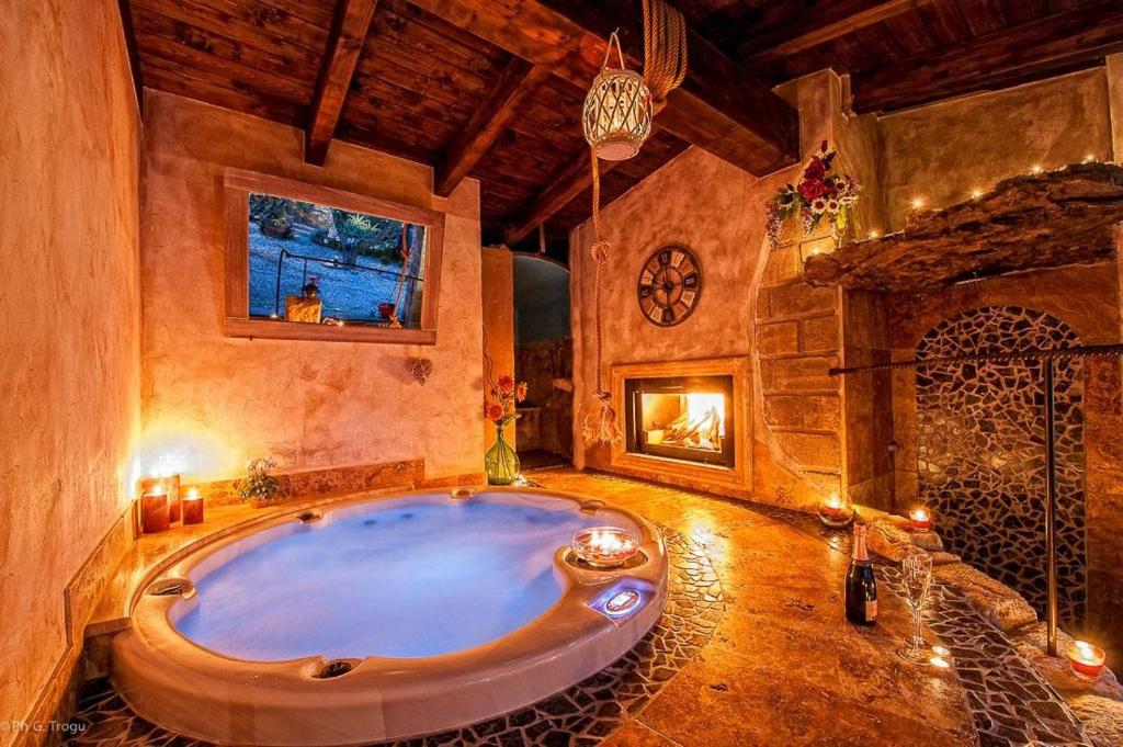a large bath tub in a room with a fireplace at Il Giardino dei Flintstones B&B in Cerveteri