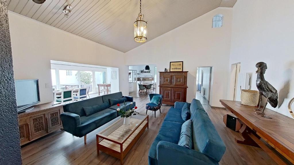 un salon avec un canapé bleu et une télévision dans l'établissement Villa de Prestige à 400m de la plage Prestige CAMIMAX à 400m de la plage, à La Faute-sur-Mer