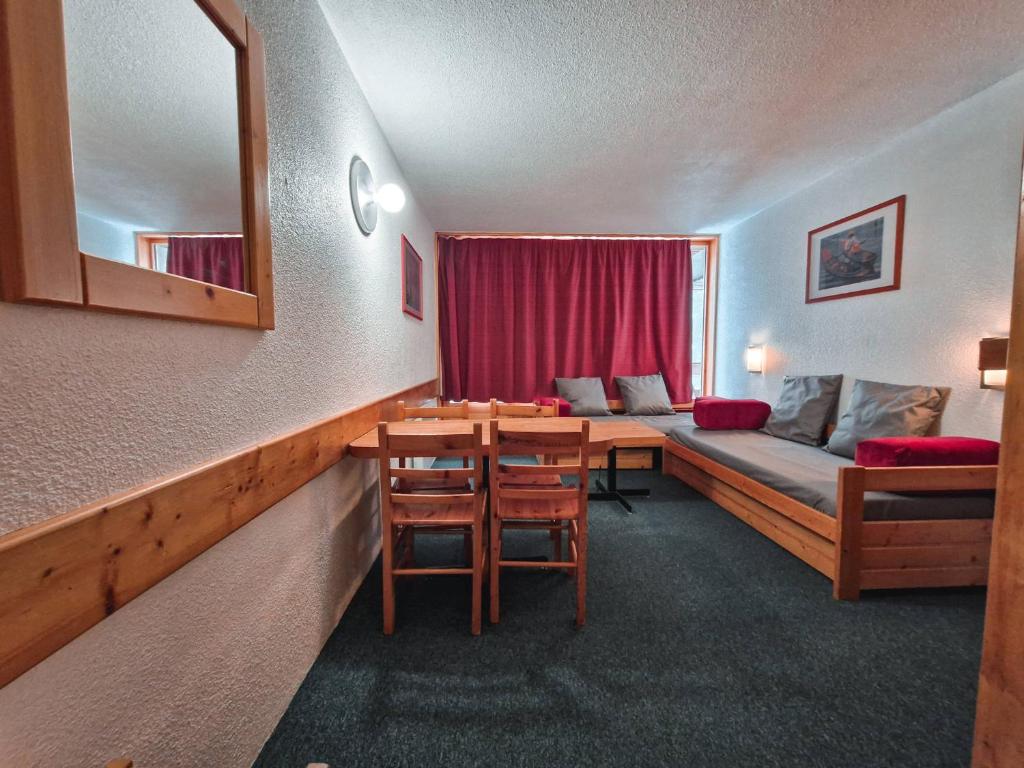Cette chambre comprend un lit, une table et un canapé. dans l'établissement Studio 5 pers skis aux pieds, proche commerces, animaux admis à Arc 1800 - FR-1-411-199, à Arc 1800