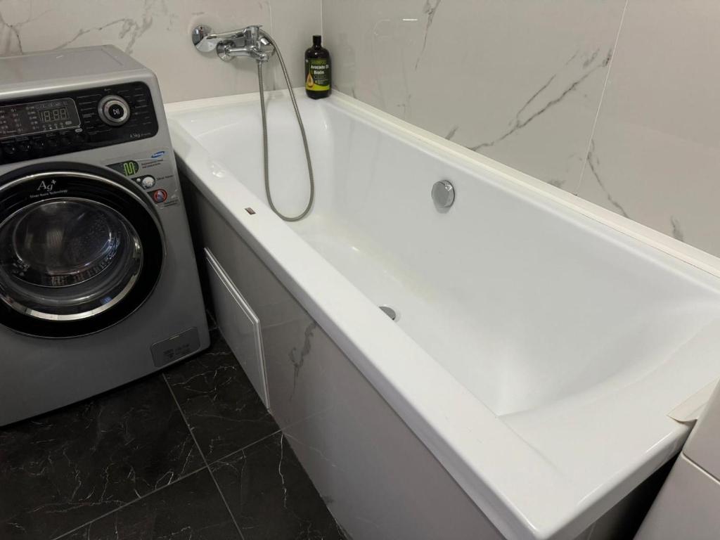 biała wanna z pralką w łazience w obiekcie Opera apartment w Kiszyniowie