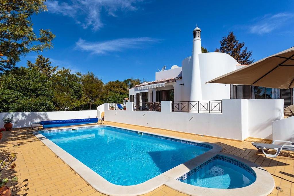 ein Swimmingpool vor einem Haus mit einem Leuchtturm in der Unterkunft Casa Floresta - Fabulous villa in Poço Partido