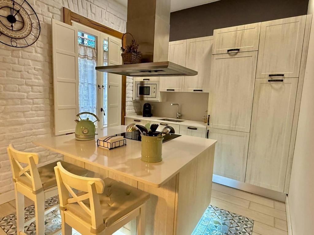 une cuisine avec un comptoir et un îlot avec des chaises dans l'établissement Amuma Justina Etxea , Apartamento en casco antiguo, à Bermeo