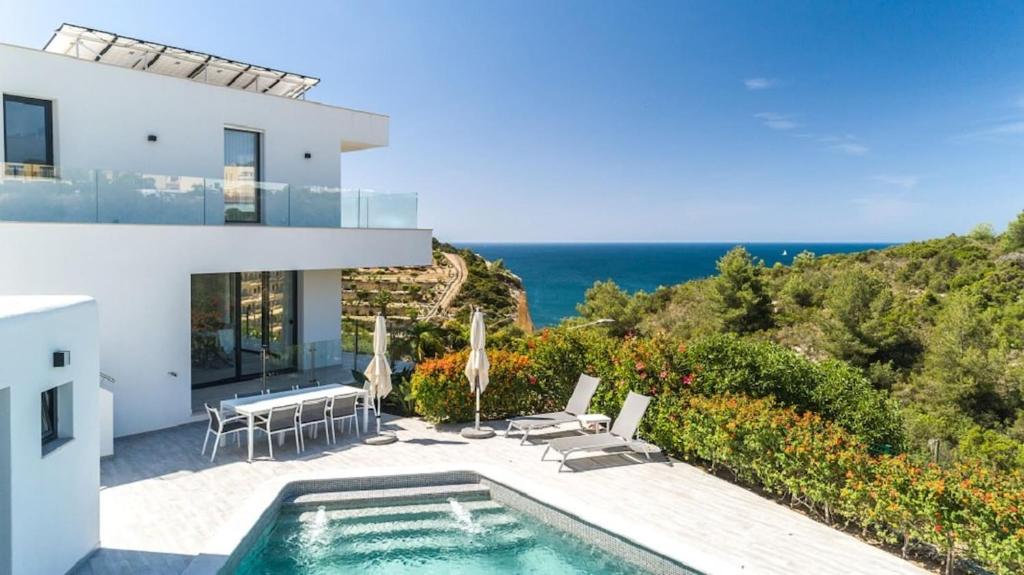 a villa with a swimming pool and the ocean at Villa Centeanes - Luxury villa in Carvoeiro