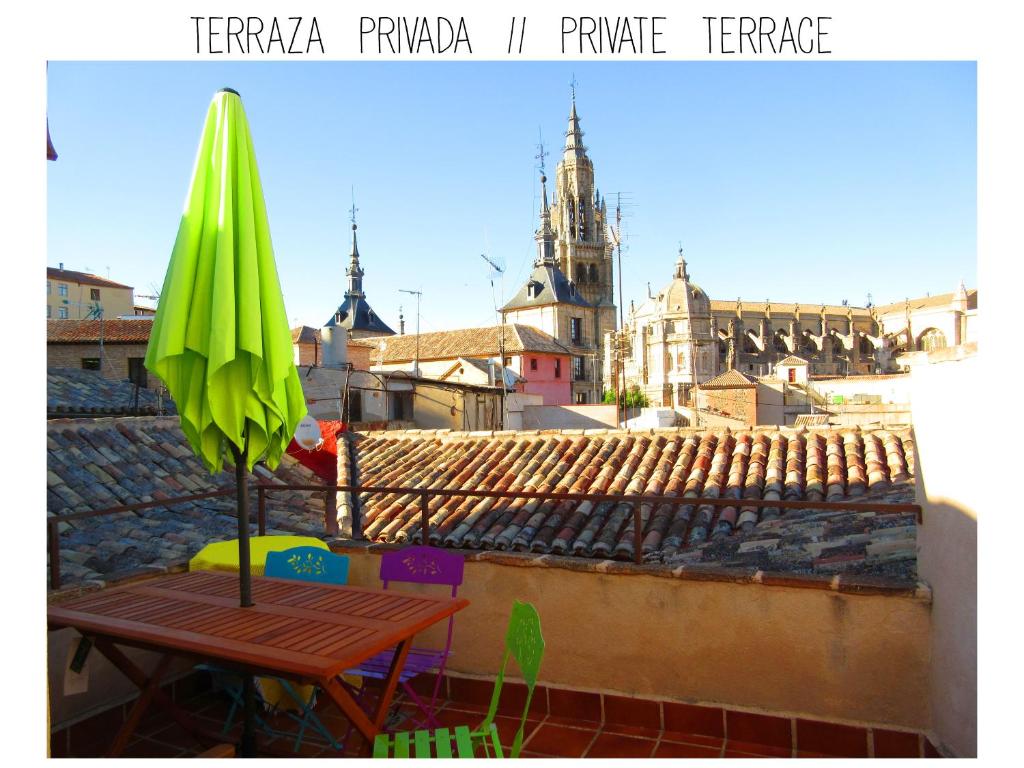 una sombrilla verde y una mesa en la azotea en Casa Catedral - terraza privada con vistas en el corazón de Toledo, en Toledo
