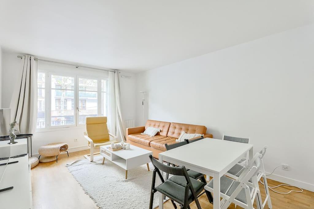 un salon avec un canapé et une table dans l'établissement Stunning 2BR Flat near Charonne metro station, à Paris