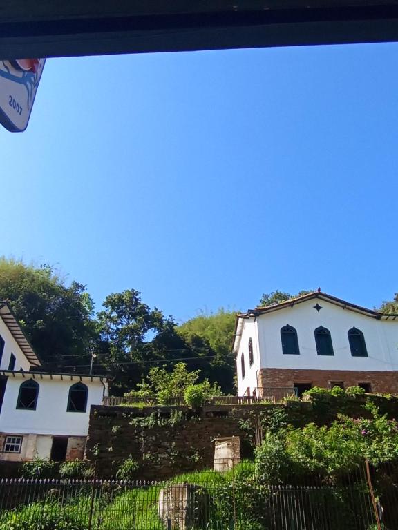 a view of two white houses with a fence at República Engenho Quarto Casal in Ouro Preto