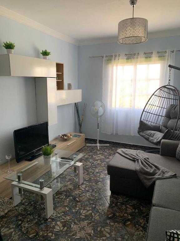 a living room with a couch and a glass table at Vacacional Tegueste 1ºA in Vecindario
