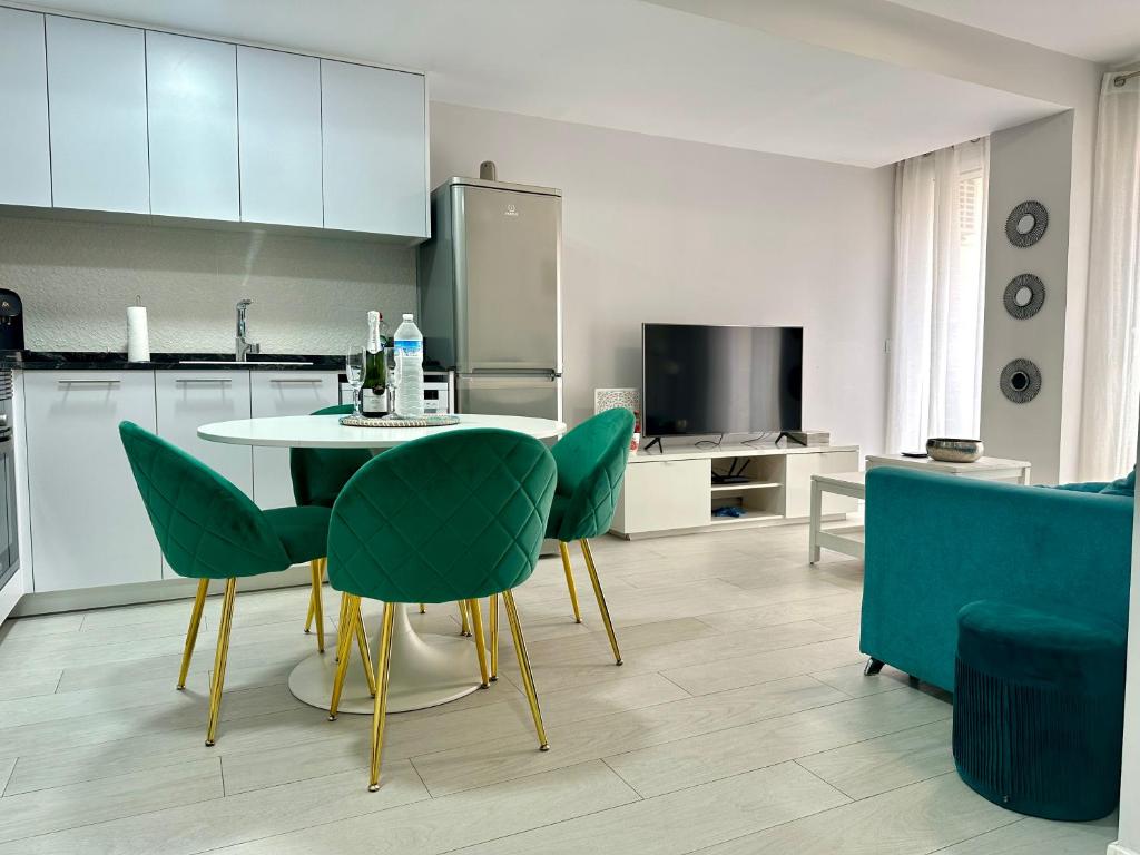 a kitchen with a table and green chairs in a room at Reinapart Valencia Beach in Valencia