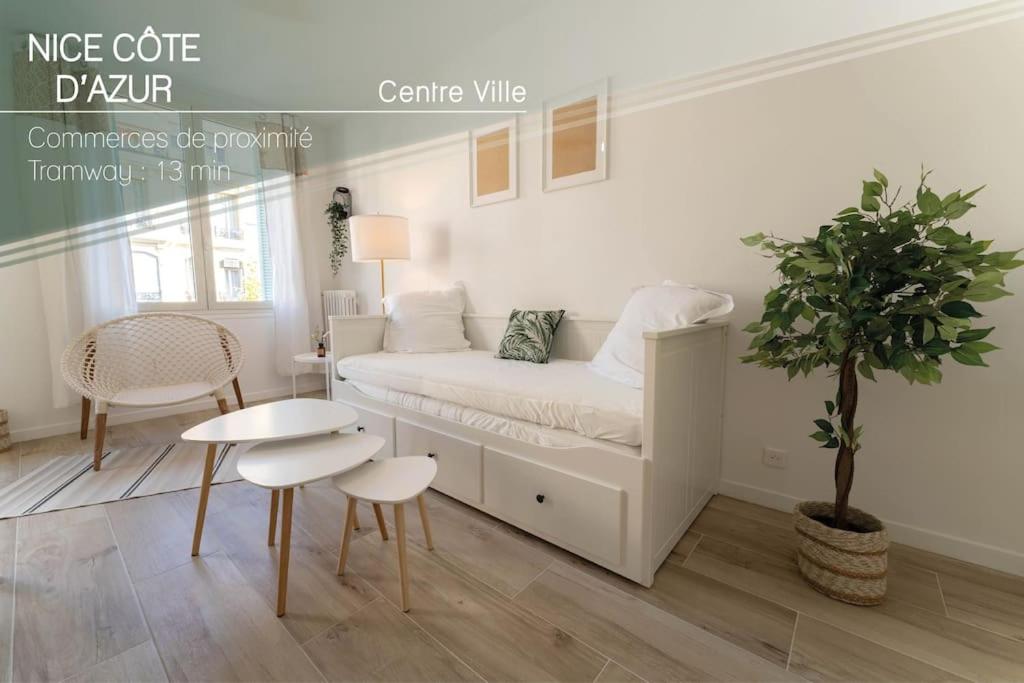 Cette chambre blanche comprend un lit, une table et une plante. dans l'établissement PF1 Studio terrasse, Centre, Proche Tramway, à Nice