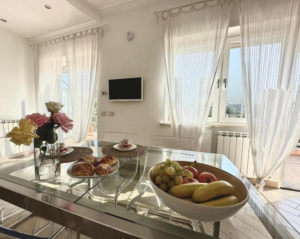 un tavolo di vetro con un cesto di frutta sopra di Terrazza sul Parco a Roma