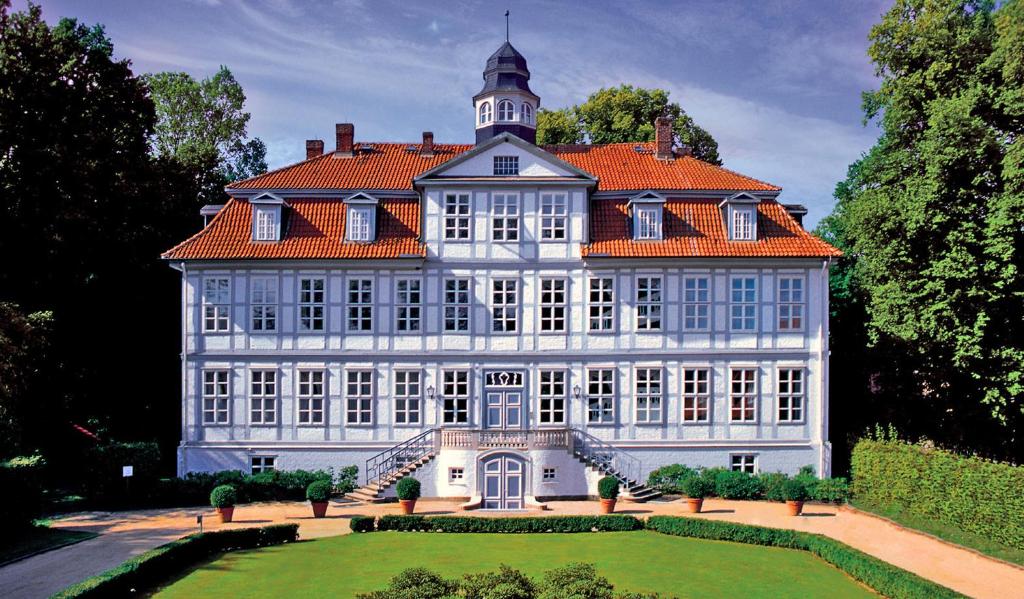 ein großes weißes Gebäude mit orangefarbenem Dach in der Unterkunft Schloss Lüdersburg Golf & Spa in Lüdersburg