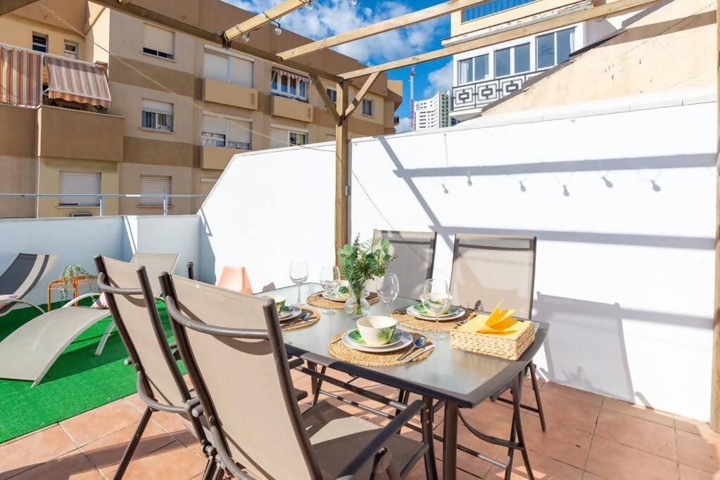 a table and chairs on the balcony of a apartment at Ático soleado en el centro de Málaga in Málaga