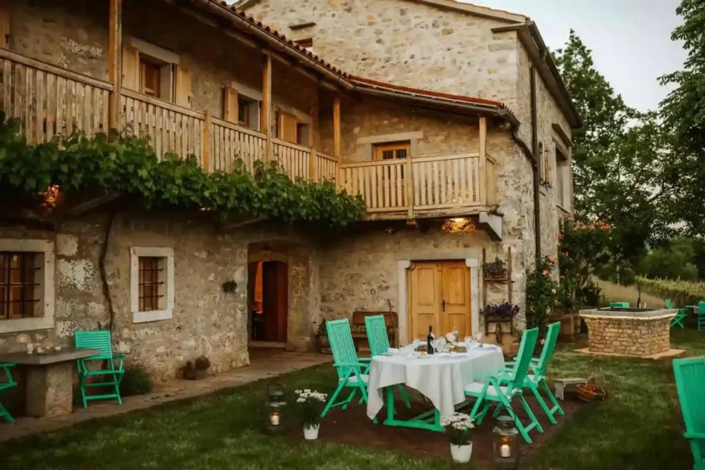 a table and chairs in front of a building at Opulent Villa with Sauna in the Heart of Karst in Dutovlje