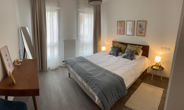 a bedroom with a large bed with pillows on it at DOMITYS - La Flânerie in Béthune