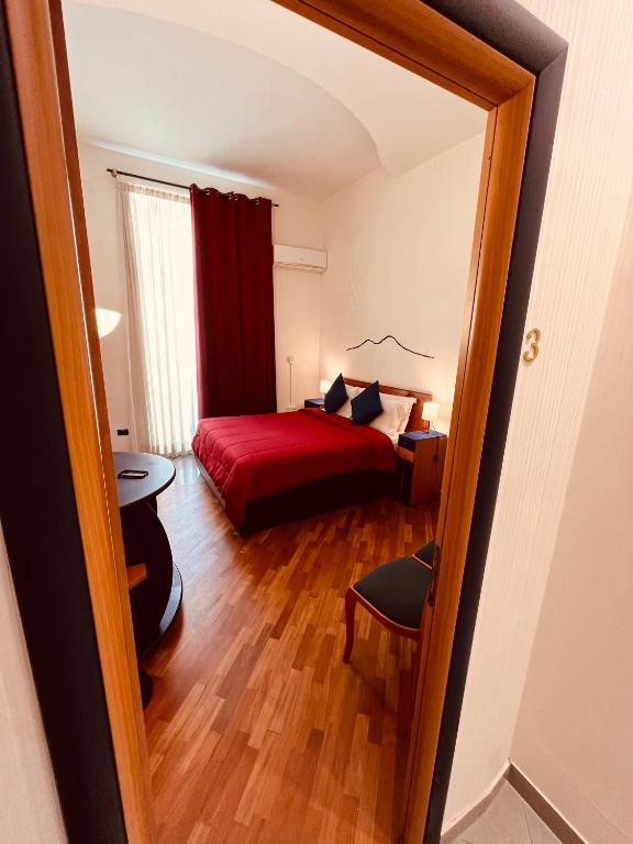 a small bedroom with a red bed and a mirror at LaNova21 in Naples