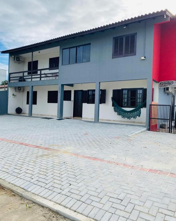 a large white building with a red and white at RESIDENCIAL CANTINHO PANTANEIRO in Itapoa