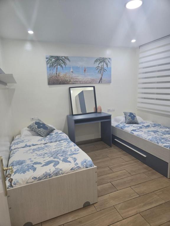 テラサにあるAlojamiento Entero Moderno En Barcelona Terrassaのベッドルーム1室(ベッド2台、鏡付)