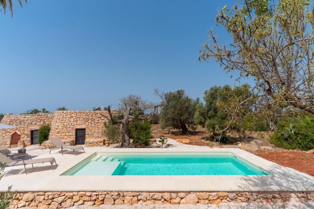 an image of a swimming pool in front of a house at Trullo dei Beneficati By Vivimy in Taviano