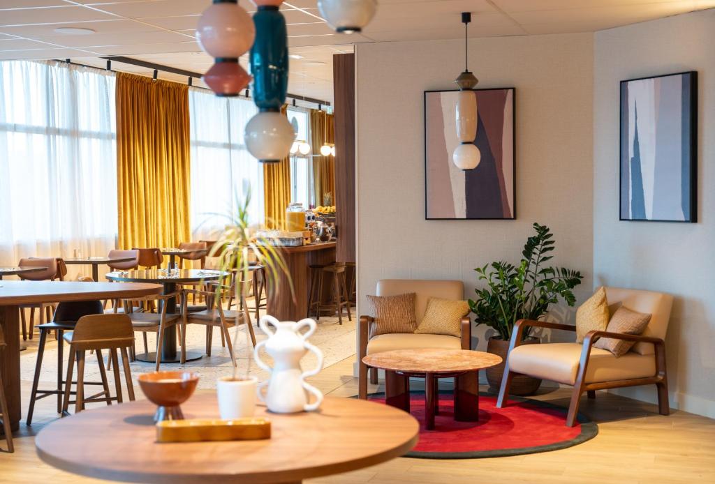 - un restaurant avec des tables, des chaises et une table dans l'établissement Novotel Nantes Centre Bord de Loire, à Nantes