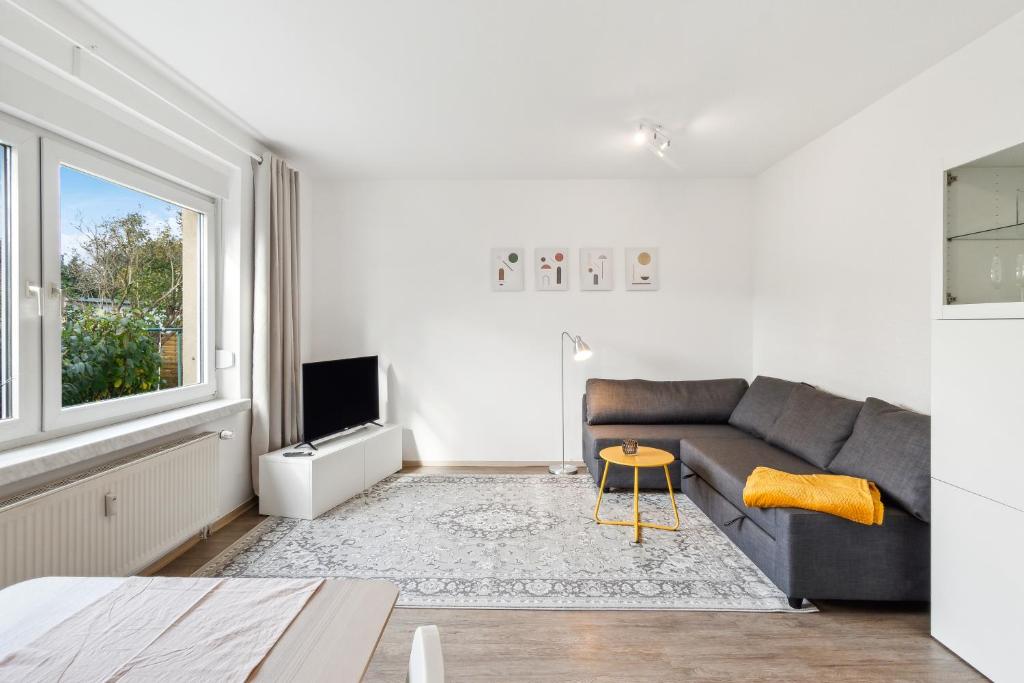 a living room with a couch and a tv at WIESE 18 im Cottbuser Süden in Cottbus