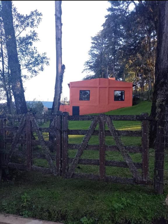 a small red house behind a wooden fence at Casa Naranja in San Javier
