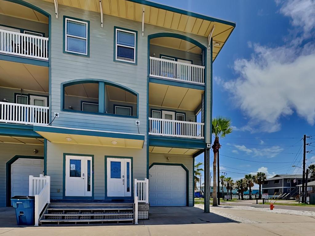 a tall blue building with two balconies at Casa Palmera in Port Aransas