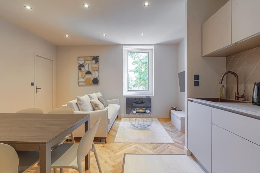 a kitchen and living room with a couch and a table at Superbe appartement, deux chambres, St-Didier in Saint-Didier-au-Mont-dʼOr